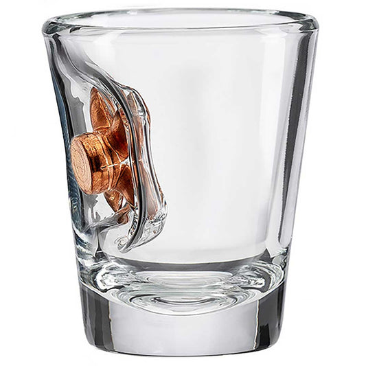 Clear shot glass with a bullet embedment on a white background