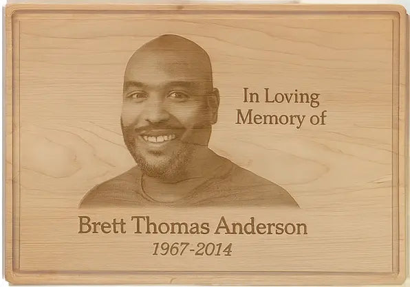 wooden cutting board with engraved photo, including a portrait of a man.