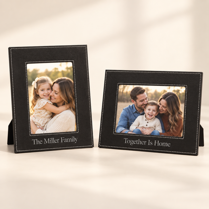 Two black personalized photo frames with white stitching and stand bases, displayed on a light beige background. 