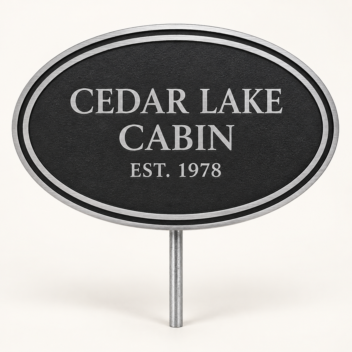Black oval cast aluminum Cedar Lake Cabin sign mounted on a silver ground stake