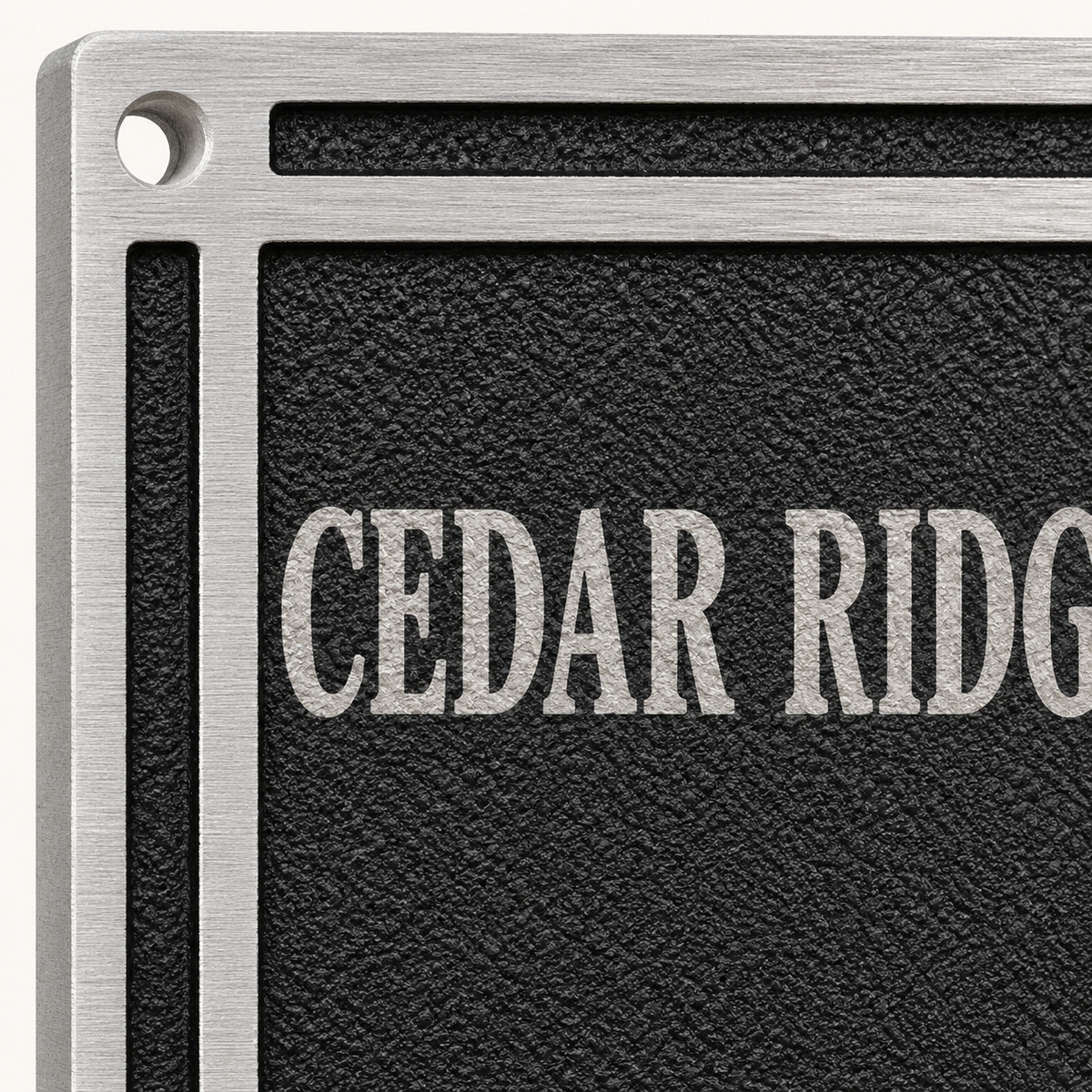Close-up of textured black cast aluminum plaque with raised silver border and lettering