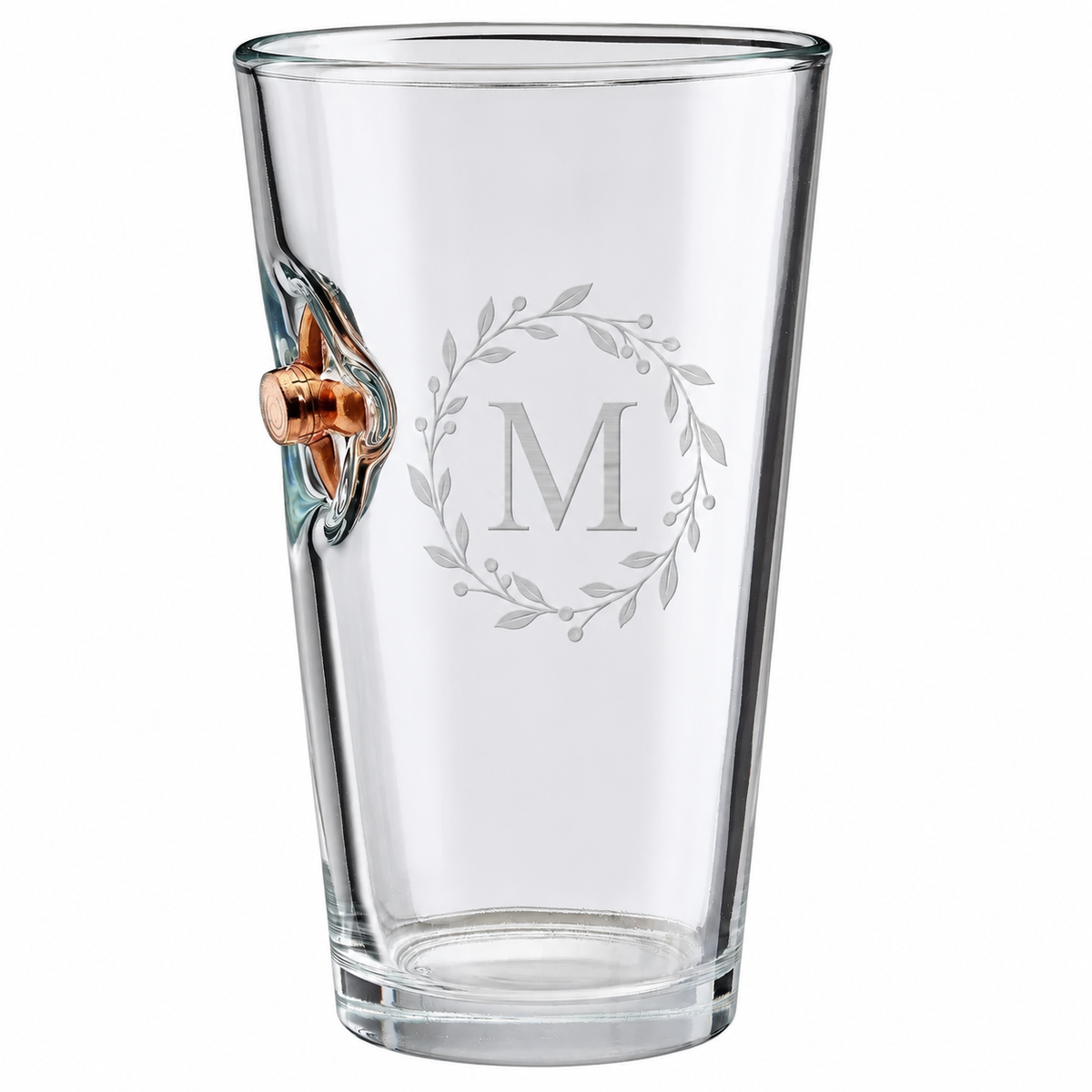 Personalized BenShot bullet pint glass engraved with an M botanical wreath beside an expanded copper bullet on a white background.