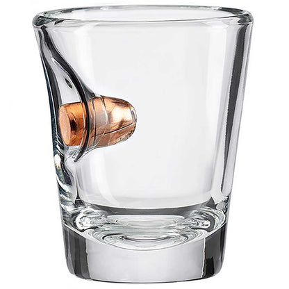 Clear shot glass with a bullet embedment on a white background