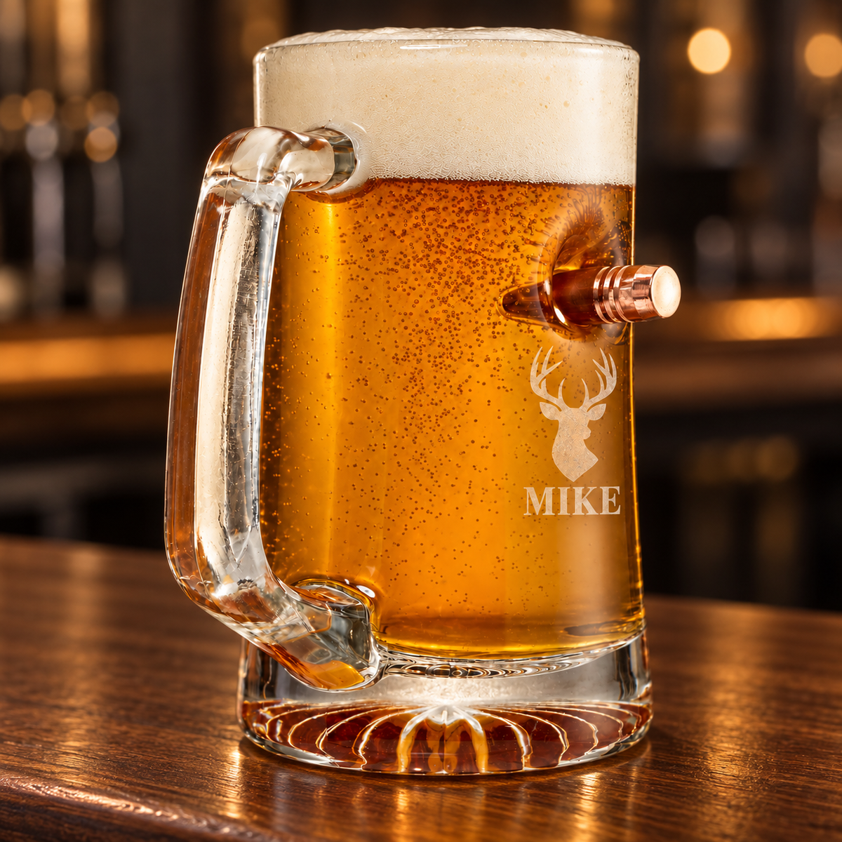 Personalized BenShot 50 BMG beer mug engraved with a deer head and MIKE beneath the embedded copper bullet, filled with beer on a warm bar.