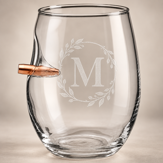 Personalized BenShot bullet wine glass engraved with a frosted botanical wreath and M monogram on a warm neutral background.