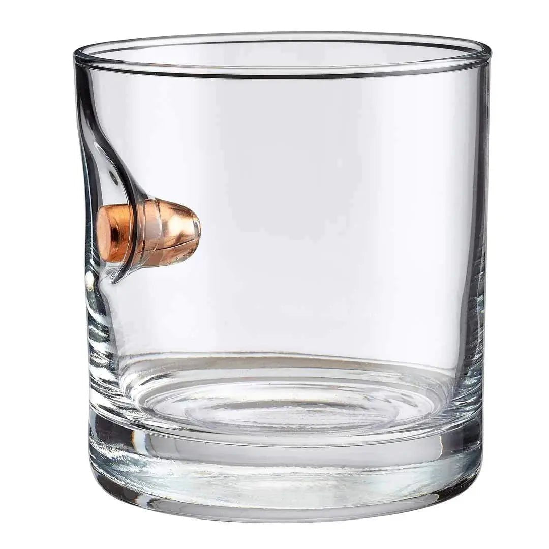 Clear glass rocks glass with a bullet embedment on a white background.