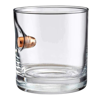 Clear glass rocks glass with a bullet embedment on a white background.