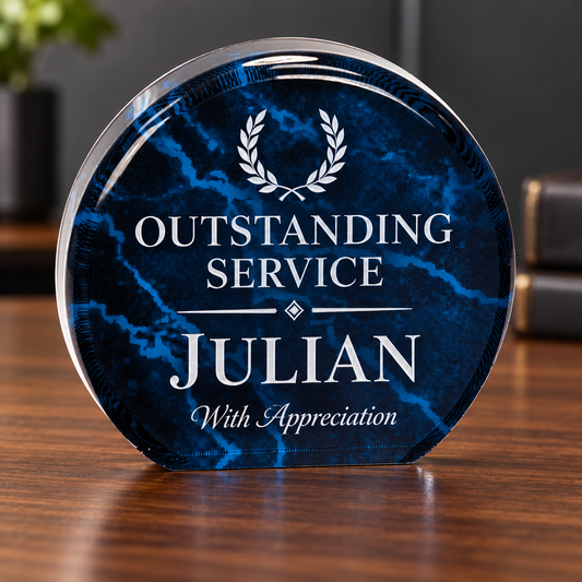 A round acrylic award plaque with a dark blue marbled pattern, featuring a white laurel wreath and the engraved text 'OUTSTANDING SERVICE JULIAN With Appreciation', displayed on a wooden table.