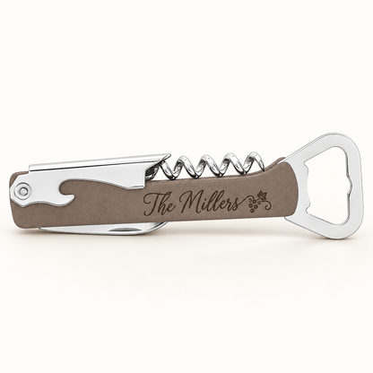 A personalized corkscrew wine bottle opener features a sleek design with a silver metal handle and a brown leatherette grip, engraved with the name The Millers.