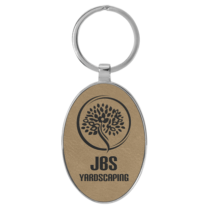 Light Brown personalized metal-frame oval leatherette keychains with example engraving