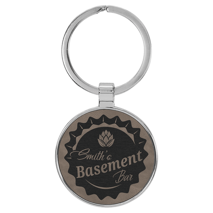 Gray personalized metal-frame round leatherette keychains with example engraving