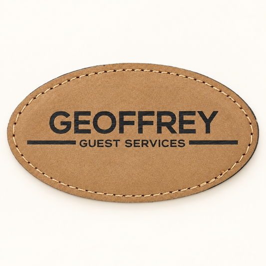 Light Brown oval leatherette magnetic name badge with dark GEOFFREY Guest Services engraving and stitched edge.