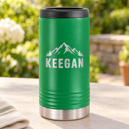 Green slim can cooler with silver KEEGAN mountain engraving and black top rim.