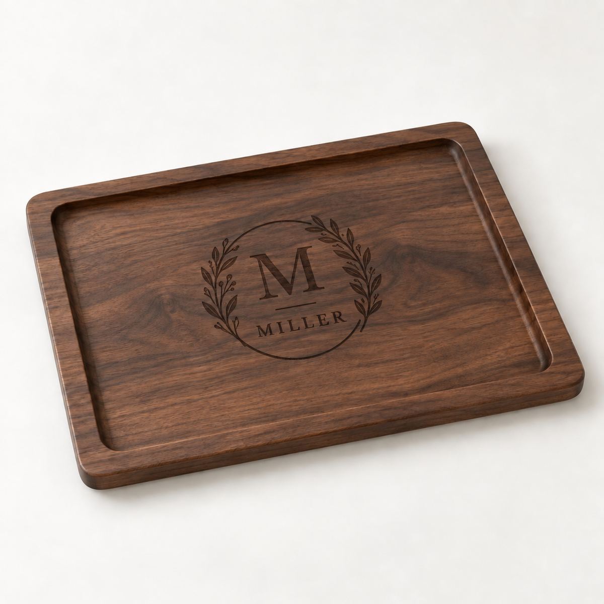 Personalized walnut wood serving tray with dark laser-engraved botanical family monogram