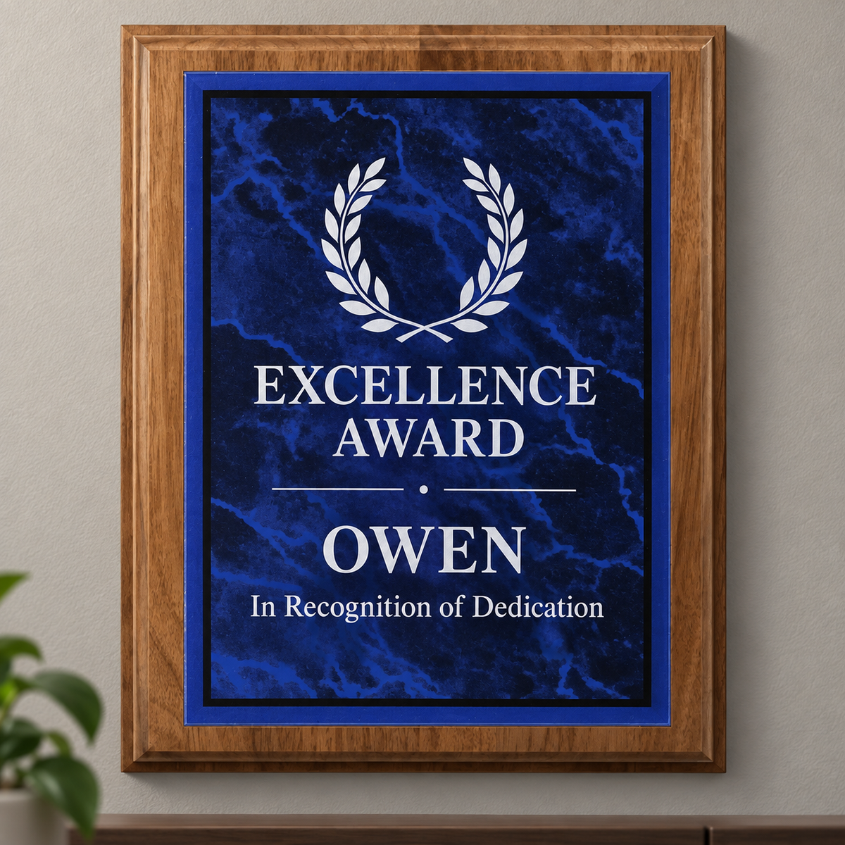 An acrylic plated custom award plaque featuring a blue marble plate with a white laurel wreath and the text 'EXCELLENCE AWARD OWEN In Recognition of Dedication'.